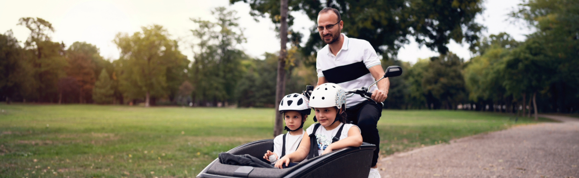 man met twee kinderen in de bakfiets