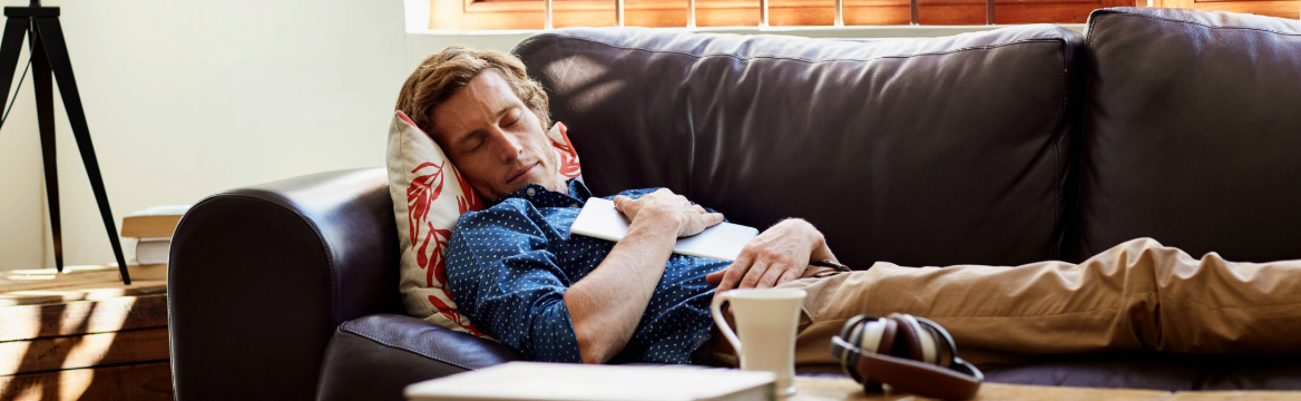 man ligt op de bank