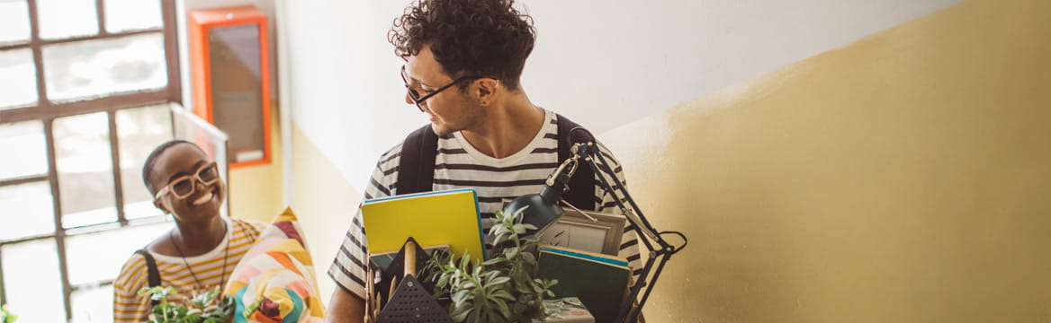 man en vrouw lopen de trap op met verhuisdozen
