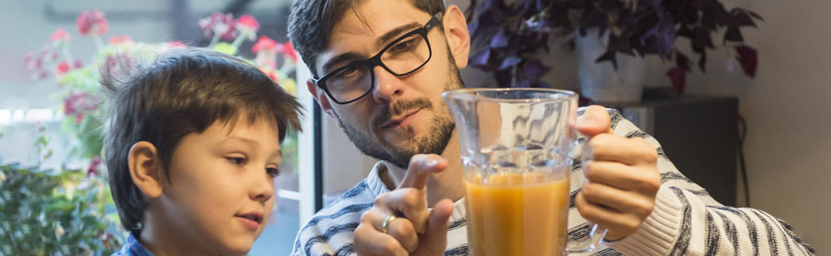 Vader en zoon kijken naar afmeting glas drinken