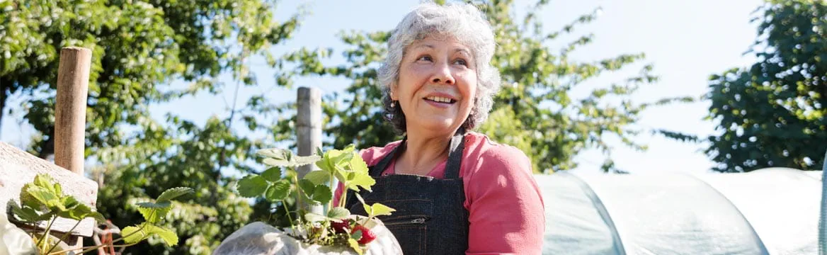 oudere vrouw in tuin met groenten