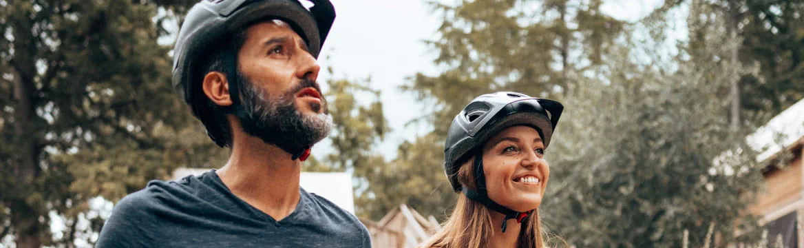 man en vrouw staat bij hun fiets in natuurlijke omgeving