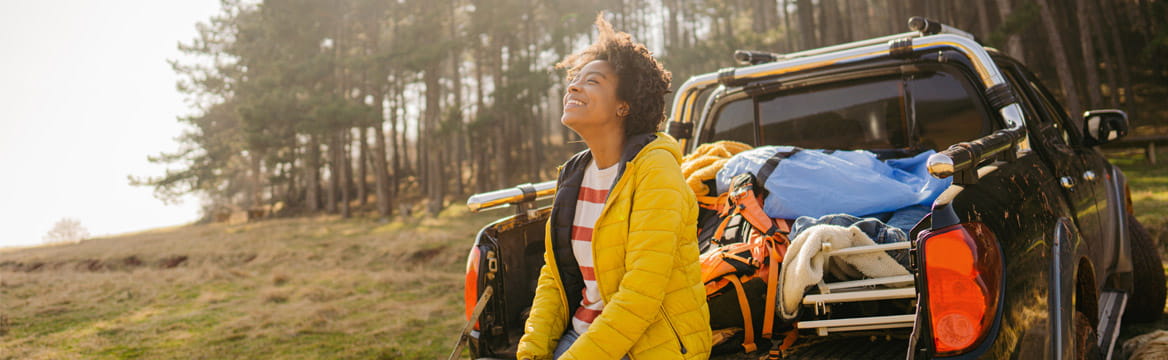 vrouw bij auto in natuurlijke omgeving