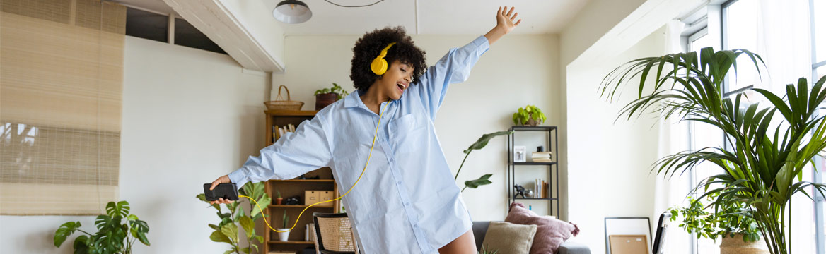 vrouw danst met koptelefoon op in huis