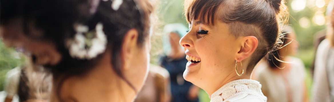 twee vrouwen lachend op hun bruiloft