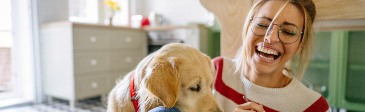 vrouw zit lachend te eten op de grond met hond