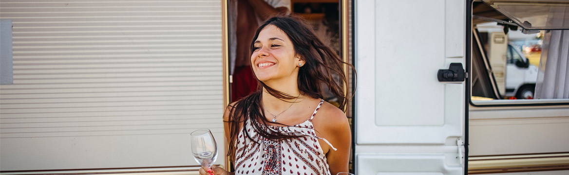 jonge vrouw lachend met wijnglazen voor caravan