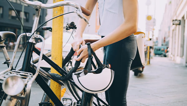 Foto dame die fiets op slot zet - OpGroen fietsverzekering