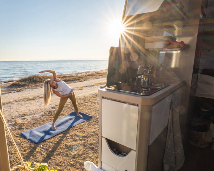 En vrouw staat in de deuropening van een camper