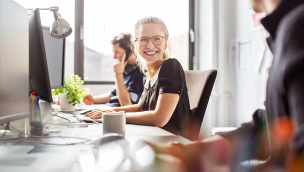 Collega's in overleg vanachter hun bureau